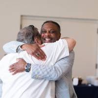 Two gentleman hugging in greeting